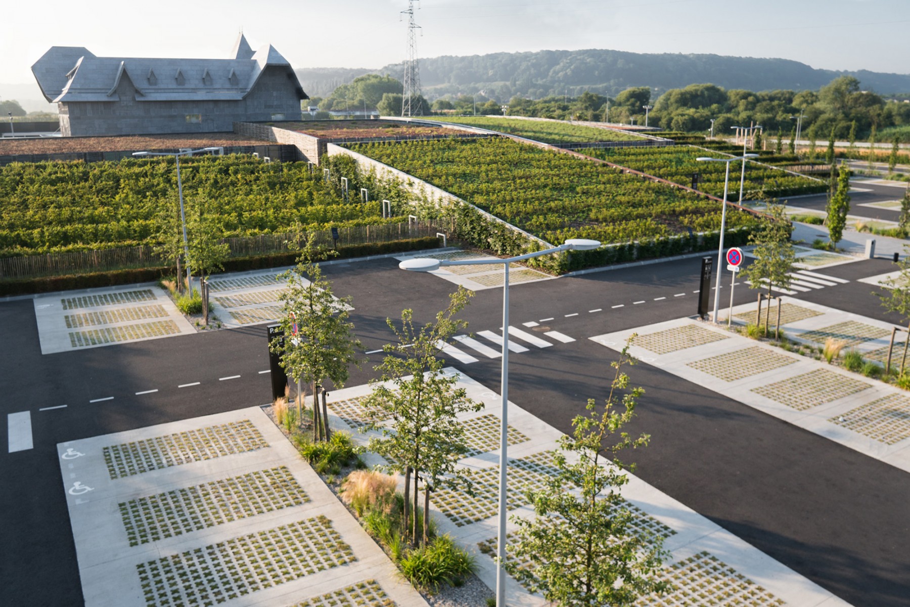 Vue sur les "collines" du "Honfleur Normandy Outlet" et son parking paysagé